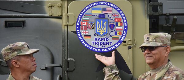 Militares junto con logo de los ejercicios militares Rapid Trident 2018 - Sputnik Mundo