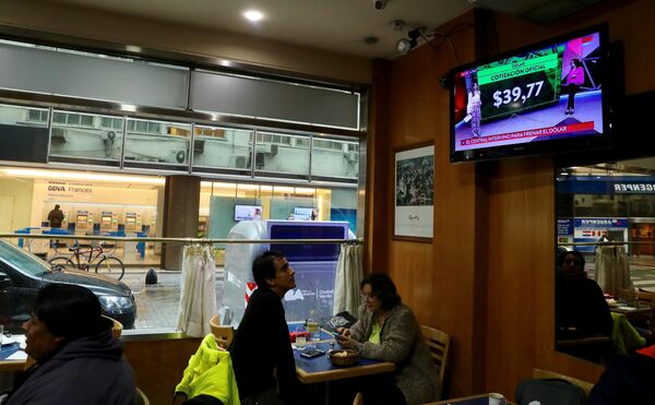 Un programa de noticias muestra las tasas de cambio del dólar en Buenos Aires, Argentina Un programa de noticias muestra las tasas de cambio del dólar en Buenos Aires, Argentina - Sputnik Mundo