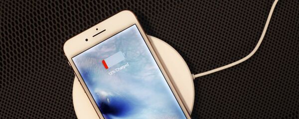 Un iPhone 8 Plus descansa en un cargador inalámbrico en Nueva York.  - Sputnik Mundo