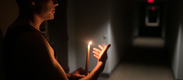 Hombre con una vela durante el huracán Florence Hombre con una vela durante el huracán Florence - Sputnik Mundo