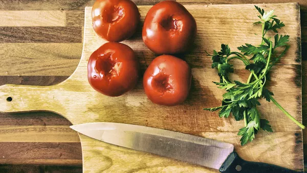 Tomates y perejil en una tabla de cortar