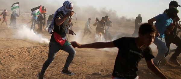 Palestinos huyen del gas lacrimógeno disparado por las tropas israelíes durante una protesta en la Franja de Gaza - Sputnik Mundo