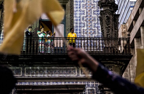 Trabajadores observan a los estudiantes que pasan con banderas de la UNAM durante la Marcha del Silencio 2018, en la Ciudad de México. - Sputnik Mundo