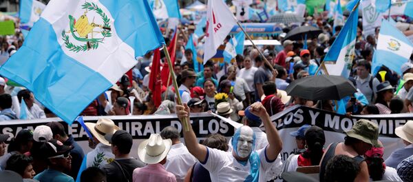 Un manifestante con la bandera de Guatemala Un manifestante con la bandera de Guatemala - Sputnik Mundo