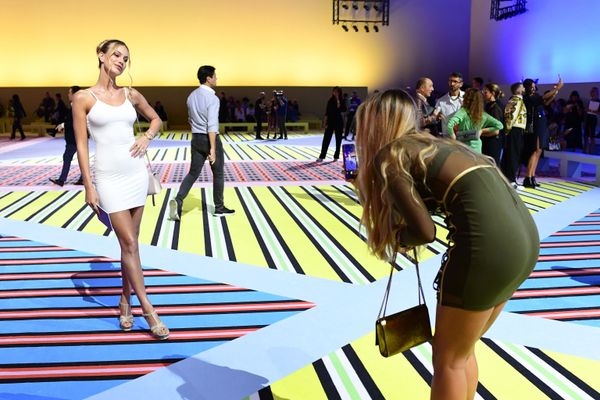 En Italia, a la moda se la considera una cuestión de Estado. En la foto, los asistentes a la muestra se hacen fotos justo antes de que las modelos comiencen a desfilar con la nueva colección de Versace. - Sputnik Mundo