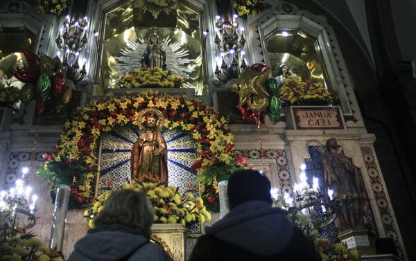 Dos creyentes rezan frente a la imagen de San Judas Tadeo en el Templo de San Hipólito, en la Ciudad de México - Sputnik Mundo