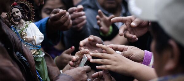 Fieles reciben imágenes de San Judas Tadeo que se reparten fuera del Templo de San Hipólito en la Ciudad de México - Sputnik Mundo