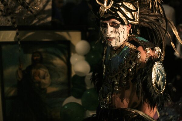 Danzante con traje prehispánico ofrece limpias frente a un cuadro de San Judas Tadeo en el Templo de San Hipólito en la Ciudad de México - Sputnik Mundo