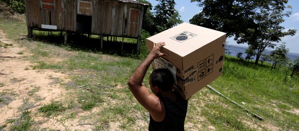 Un obrero lleva la caja urna de votación a una comunidad en el río Amazonas - Sputnik Mundo