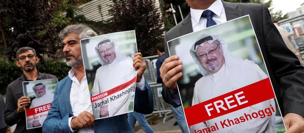 Personas con retratos del periodista opositor saudí Jamal Khashoggi protestan cerca del consulado saudí - Sputnik Mundo