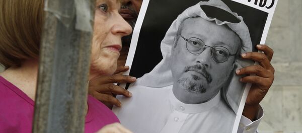 Personas con retratos del periodista saudí Jamal Khashoggi protestan en Washington - Sputnik Mundo