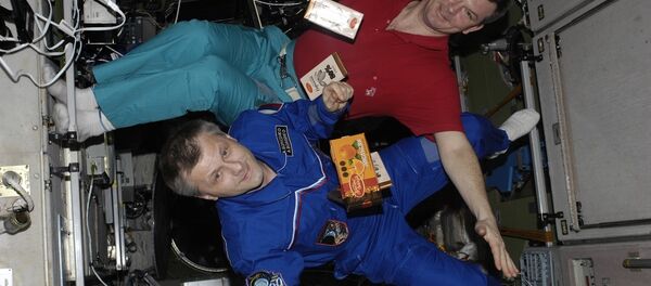 Los cosmonautas con barras de chocolate flotando en EEI - Sputnik Mundo