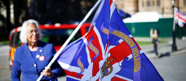 Una mujer con la bandera con nombres de condados de Irlanda del Norte - Sputnik Mundo