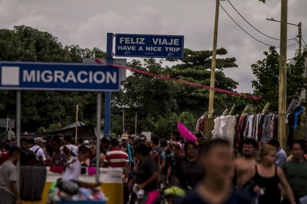 Miles de personas migrantes en el puente internacional entre Guatemala y México intentan cruzar para pedir el asilo mexicano - Sputnik Mundo