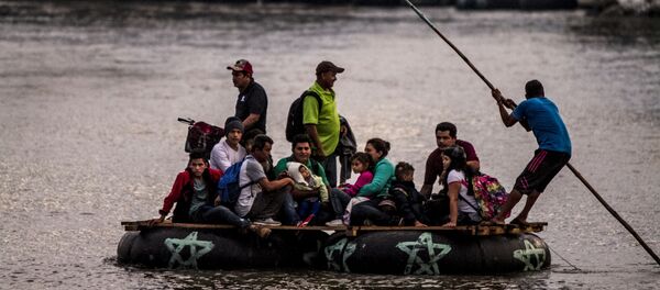Un grupo de personas centroamericanas cruza el Río Suchiate para seguir con el camino de la Caravana de Hondureños - Sputnik Mundo