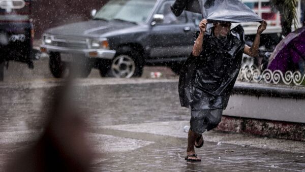 Migrante centroamericano corre de la lluvia y en el parque Miguel Hidalgo de Tapachula - Sputnik Mundo