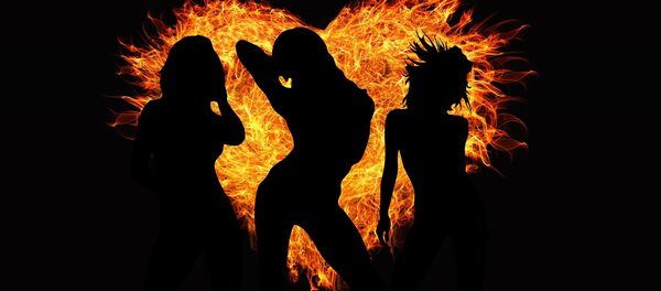 Mujeres bailan delante de un corazón de fuego - Sputnik Mundo