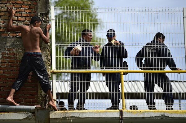 Un migrante hondureño, que se dirige a Estados Unidos, preparándose para saltar al río desde el puente fronterizo entre Guatemala y México. - Sputnik Mundo