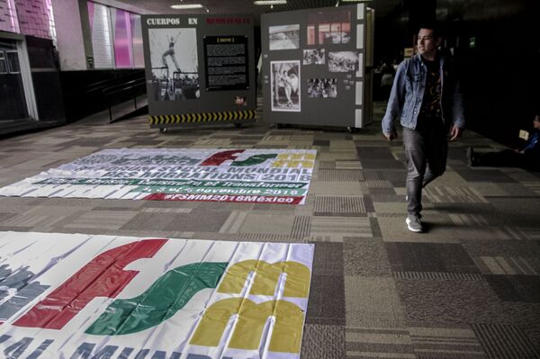 Un joven camina frente a una manta con el logotipo del 8° Foro Social Mundial de las Migraciones en México. Un joven camina frente a una manta con el logotipo del 8° Foro Social Mundial de las Migraciones en México. - Sputnik Mundo