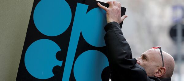 Un hombre coloca un cartel con el logotipo de la OPEP junto a la entrada de su sede antes de una reunión de ministros de petróleo de la OPEP en Viena Un hombre coloca un cartel con el logotipo de la OPEP junto a la entrada de su sede antes de una reunión de ministros de petróleo de la OPEP en Viena - Sputnik Mundo