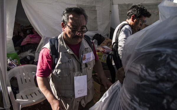Funcionario coordina los lugares en donde la gente recogerá la ropa donada Funcionario coordina los lugares en donde la gente recogerá la ropa donada - Sputnik Mundo