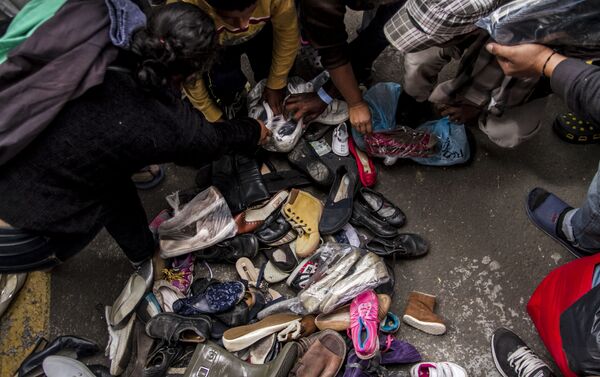 Integrantes de la segunda caravana del éxodo centroamericano buscan zapatos en buen estado que puedan utilizar Integrantes de la segunda caravana del éxodo centroamericano buscan zapatos en buen estado que puedan utilizar - Sputnik Mundo