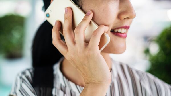 Una mujer hablando por teléfono móvil - Sputnik Mundo