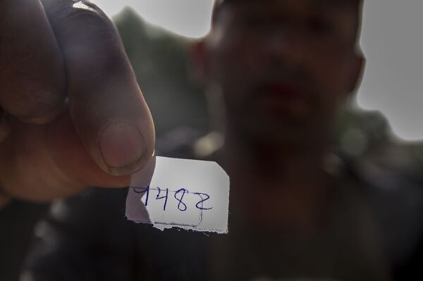 Billy Noel muestra el papelito que le dieron al pedir turno para solicitar asilo en el cruce fronterizo de San Ysidro - Sputnik Mundo