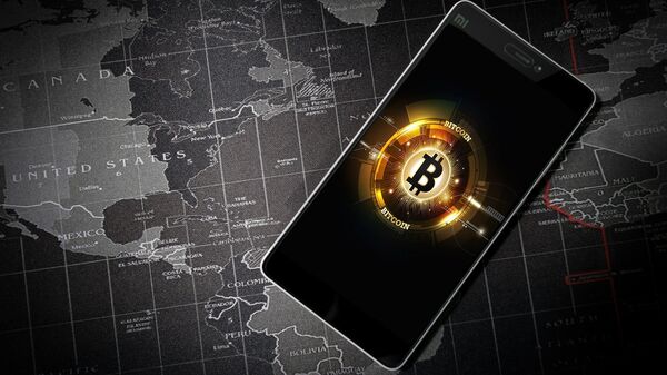 Un móvil con la imagen del logo de bitcoin - Sputnik Mundo