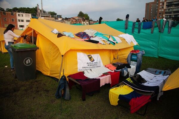 Pese a los esfuerzos del distrito de Bogotá por proveer alimentación y cobijo a los inmigrantes venezolanos, varios de ellos se quejan por la escasez de alimentos y la falta de frazadas, mientras otros aprovechan un poco de sol para lavar y secar su ropa en las carpas - Sputnik Mundo