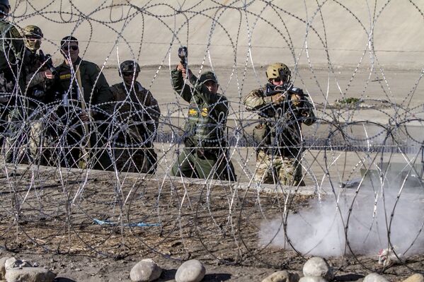 W. Lopez y D. Cody oficiales de la USBP (border patrol) disparan gases lacrimógenos contra la manifestación de centroamericanos en territorio mexicano - Sputnik Mundo