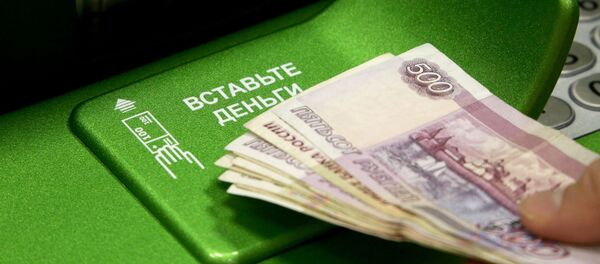 Rublos rusos y un cajero automático (imagen referencial) - Sputnik Mundo