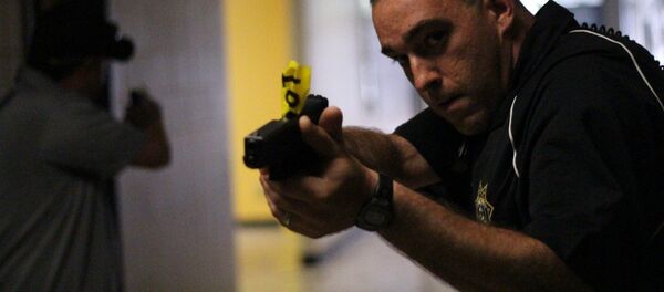 Un policía apunta un arma - Sputnik Mundo