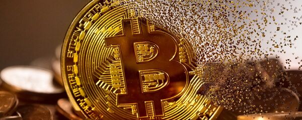 Un bitcoin haciéndose añicos - Sputnik Mundo