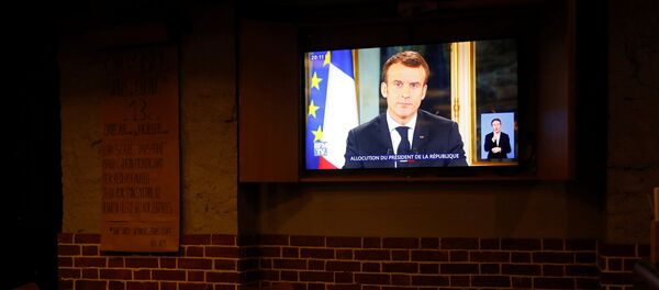 El presidente de Francia, Emmanuel Macron, en la pantalla de una tele - Sputnik Mundo