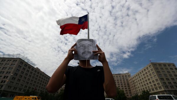 Un manifestante con el retrato del comunero mapuche Camilo Catrillanca - Sputnik Mundo