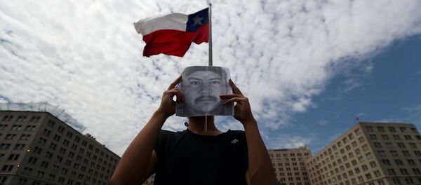 Un manifestante con el retrato del comunero mapuche Camilo Catrillanca - Sputnik Mundo