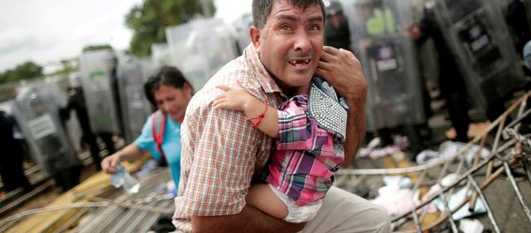 Un migrante trata desesperadamente de proteger a su bebé durante un choque en el cruce de la frontera entre México y Guatemala, el 19 de octubre de 2018 Un migrante trata desesperadamente de proteger a su bebé durante un choque en el cruce de la frontera entre México y Guatemala, el 19 de octubre de 2018 - Sputnik Mundo