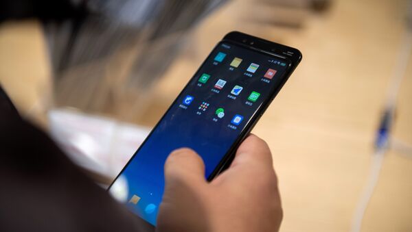 Un hombre con un teléfono de Xiaomi en Pekín - Sputnik Mundo