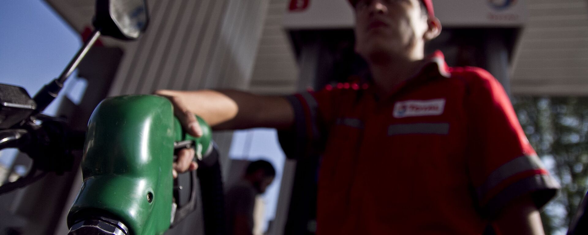 Trabajador de una gasolinera llena el tanque de una motocicleta - Sputnik Mundo, 1920, 21.06.2023