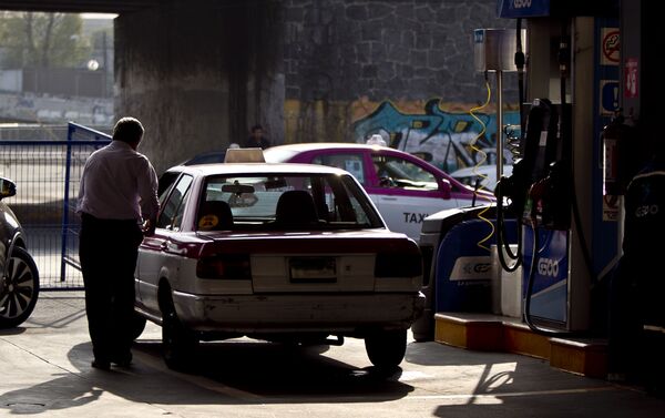 Taxista al terminar de llenar su tanque de gasolina. La mayoría de las filas están llena de taxistas - Sputnik Mundo