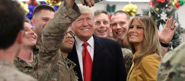 Donald Trump, presidente de EEUU, y su esposa, Melania, posan para una foto al lado de soldados estadounidenses en Irak Donald Trump, presidente de EEUU, y su esposa, Melania, posan para una foto al lado de soldados estadounidenses en Irak - Sputnik Mundo