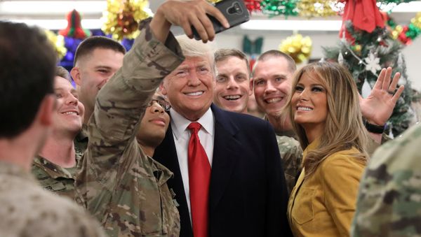 Donald Trump, presidente de EEUU, y su esposa, Melania, posan para una foto al lado de soldados estadounidenses en Irak Donald Trump, presidente de EEUU, y su esposa, Melania, posan para una foto al lado de soldados estadounidenses en Irak - Sputnik Mundo