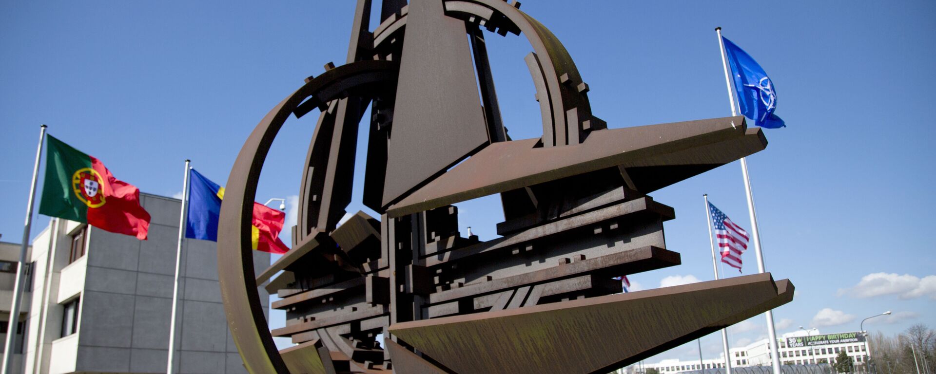 El símbolo de la OTAN y las banderas de Estados que forman parte del bloque militar.  - Sputnik Mundo, 1920, 27.03.2022