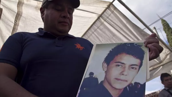 Hermano muestra la fotografía de Cesar Uriel Peña Linares de 23 años desparecido tras la explosión de un ducto de Pemex que dejó al menos 79 personas fallecidas