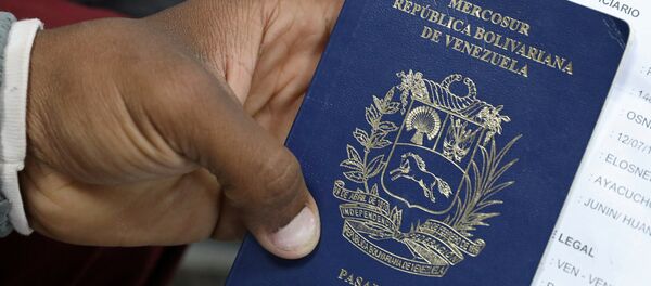 Un migrante venezolano muestra su pasaporte - Sputnik Mundo