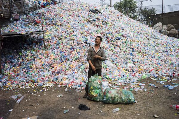 Un chino recicla botellas de plástico en el pueblo de Dong Xiao Kou, a las afueras de Pekín (China) - Sputnik Mundo