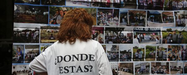Una persona tiene una camiseta en memoria de los desaparecidos de Ayotzinapa, en México - Sputnik Mundo