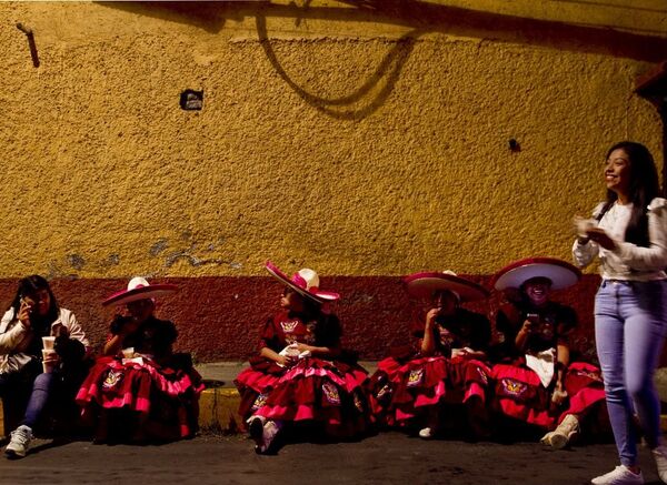 Danzantes descansan mientras comen alimentos que ofrecieron las vecinas del lugar, en el pueblo de la Candelaria, en Ciudad de México - Sputnik Mundo