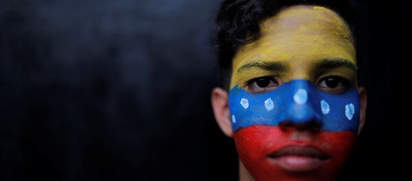 Un ciudadano con la bandera de Venezuela en su cara - Sputnik Mundo